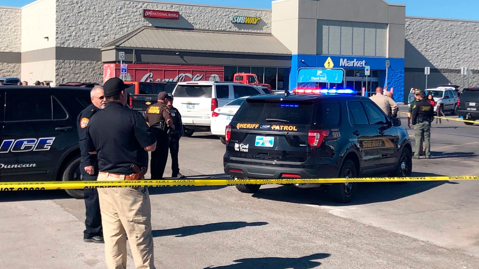 Law enforcement work the scene where two men and a woman were fatally shot Monday, Nov. 18, 2019, outside a Walmart store in Duncan, Okla.