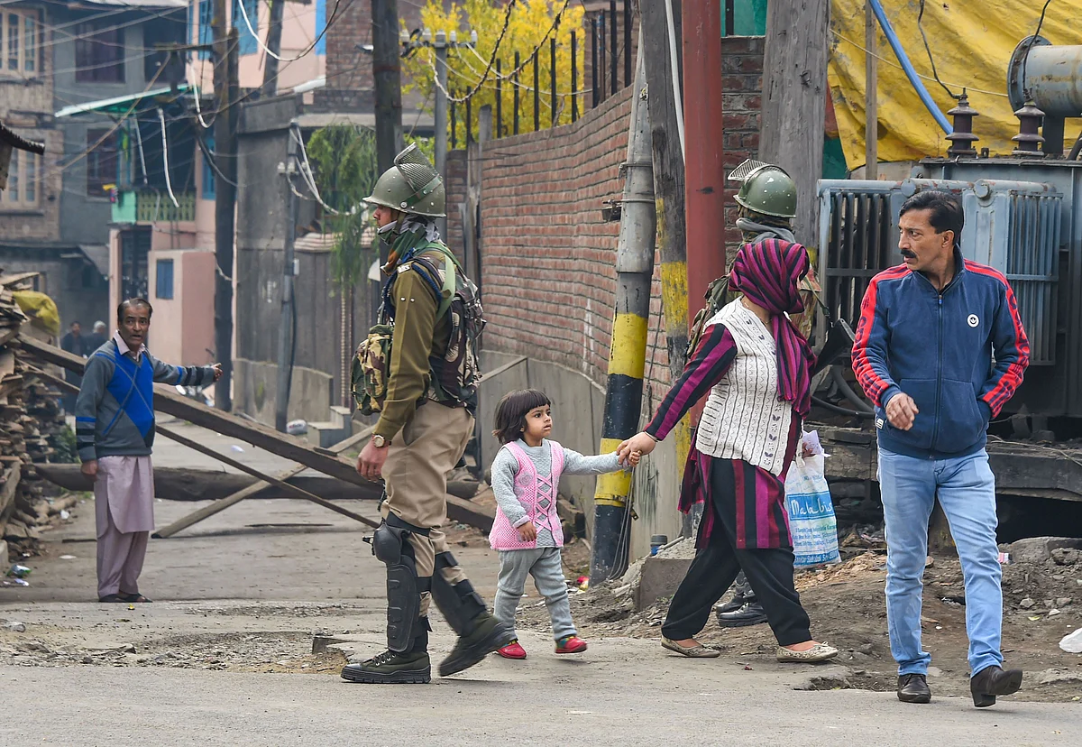 Security personnel guard in a street during restrictions in parts of Downtown in Srinagar.