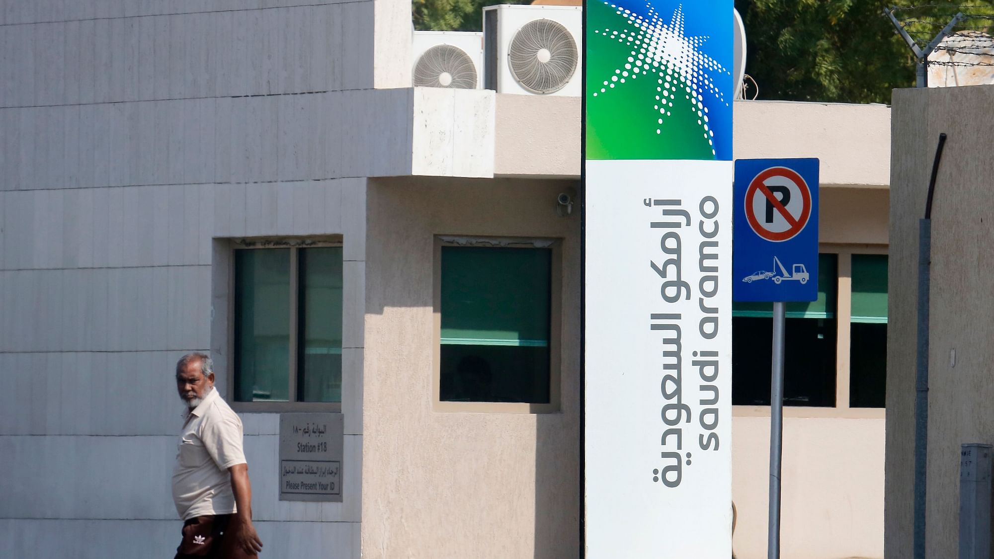 A man walks past a compound for Saudi Aramco in Jiddah, Saudi Arabia. In documents released Sunday, Saudi Arabia’s state oil giant Saudi Aramco is going to sell a 1.5% stake in its company on Riyadh’s stock exchange.