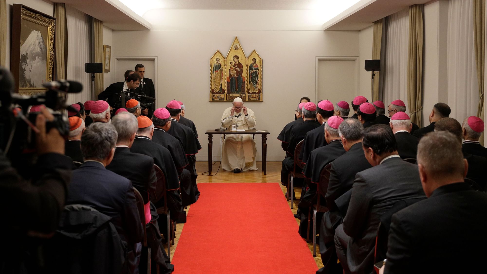 Pope Francis adjusts his glasses as he meets with Bishops at the Apostolic Nunciature in Tokyo on Saturday.