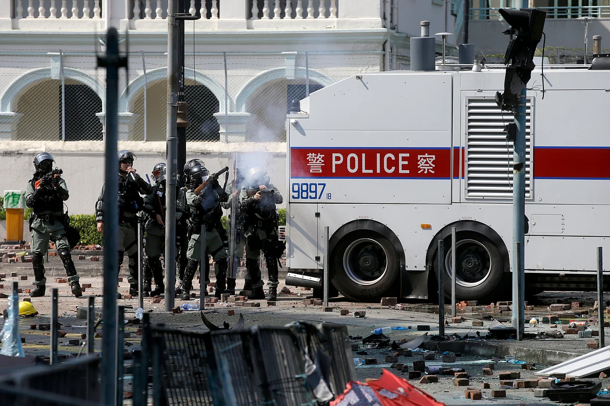 Policemen in riot gear fire teargas outside Hong Kong Polytechnic University in Hong Kong on Monday, 18 November.