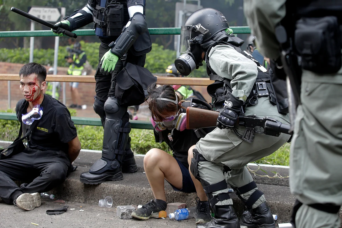 Riot police detain protesters near Hong Kong Polytechnic University in Hong Kong on Monday.