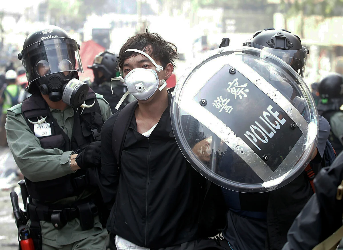 Police officers detain a protester near the Hong Kong Polytechnic University in Hong Kong on Monday, 18 November.