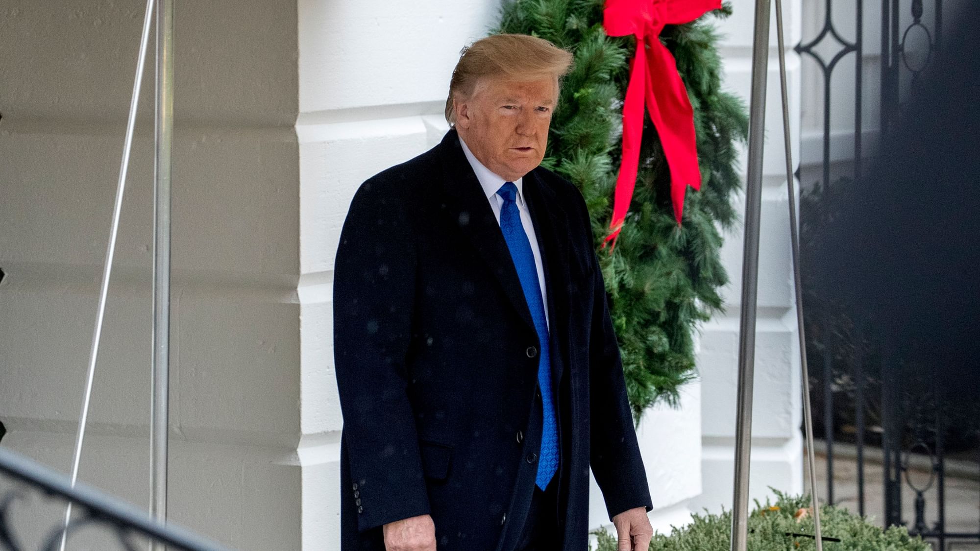 President Donald Trump walks towards members of the media before boarding Marine One on the south Lawn of the White House in Washington, on  2 December.