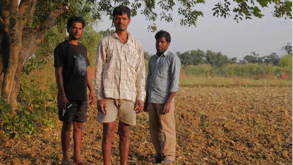 Dilip Minj, Mukesh Kujur and Illyius Minj, three residents of Nayi Toli hamlet in Garhwa’s Ranka block stand on a village farm.
