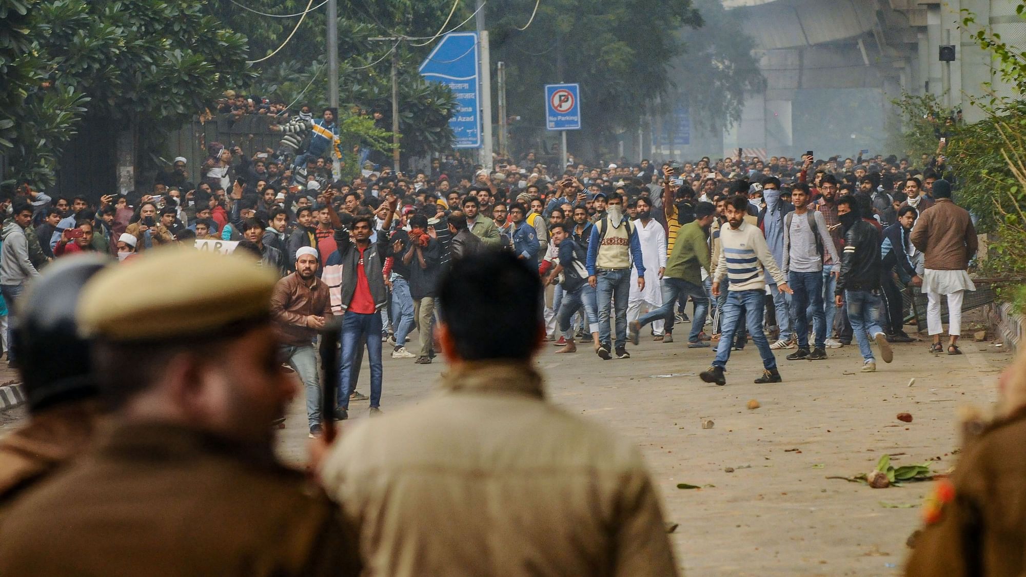 Students of Jamia Millia Islamia University clash with the police during a protest against the Citizenship Amendment Act at the University in New Delhi, Friday, 13 December.
