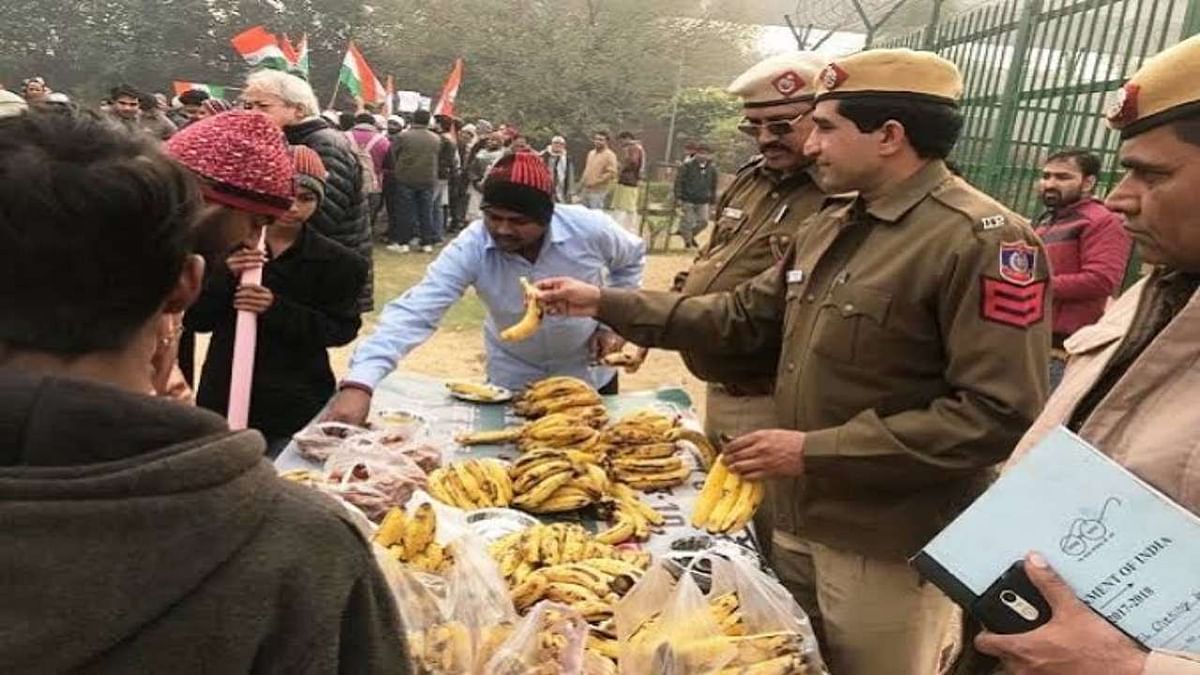 Police personnel serving bananas to detained protesters.
