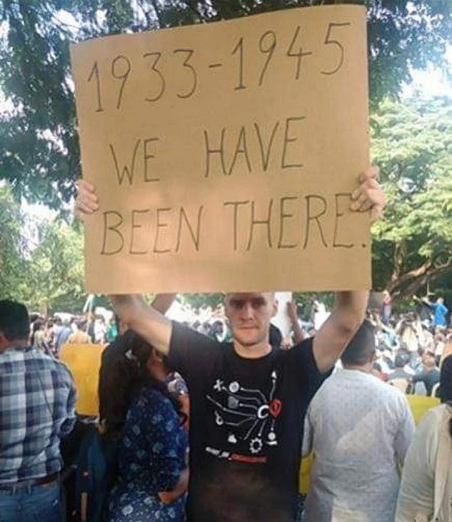 Jakob Lindenthal, a German exchange student, seen here holding a poster at one of the protests he participated in.