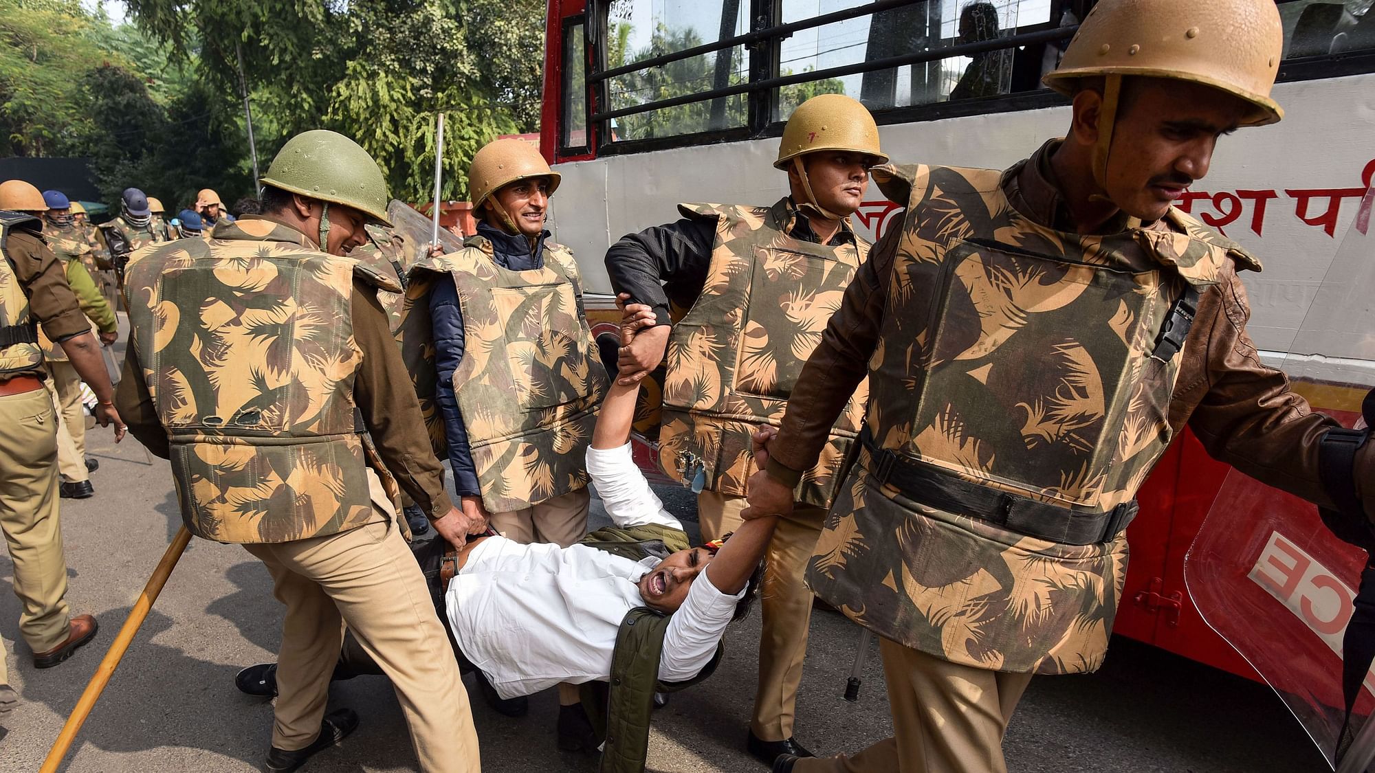 Police personnel detain Samajwadi Party workers during a protest against Citizenship (Amendment) Act, in Prayagraj.