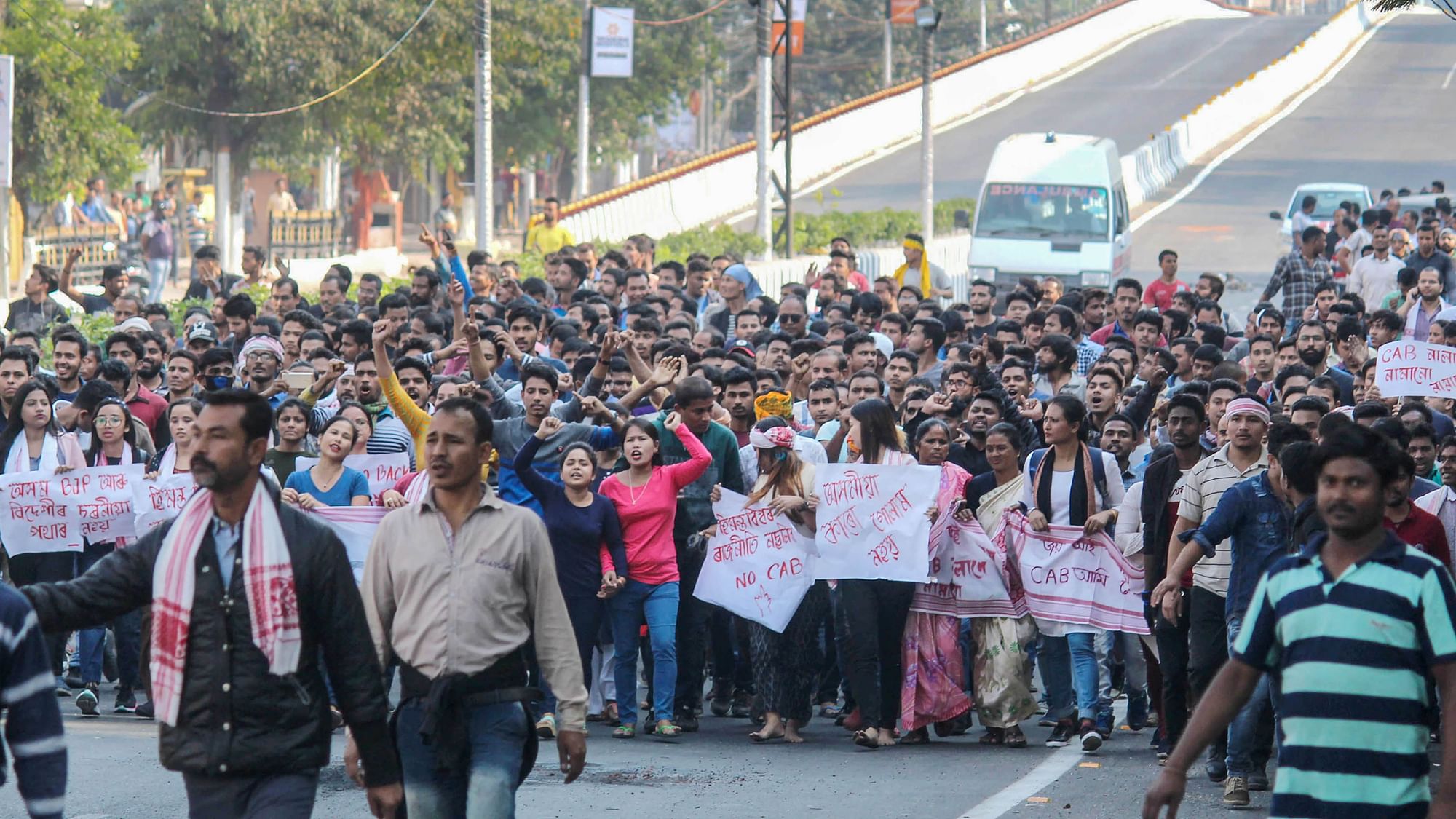 Protestors raise slogans as they take part in a demonstrationduring curfew, at GS Road in Guwahati on Thursday.