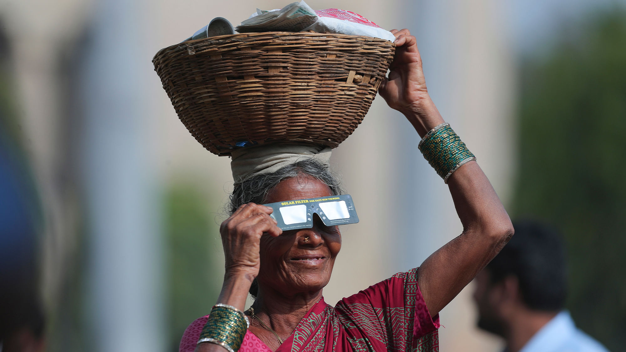 Solar Eclipse 2019 (Surya Grahan) Photos: A roadside vendor holds a special filter and watches a partial solar eclipse in Hyderabad.