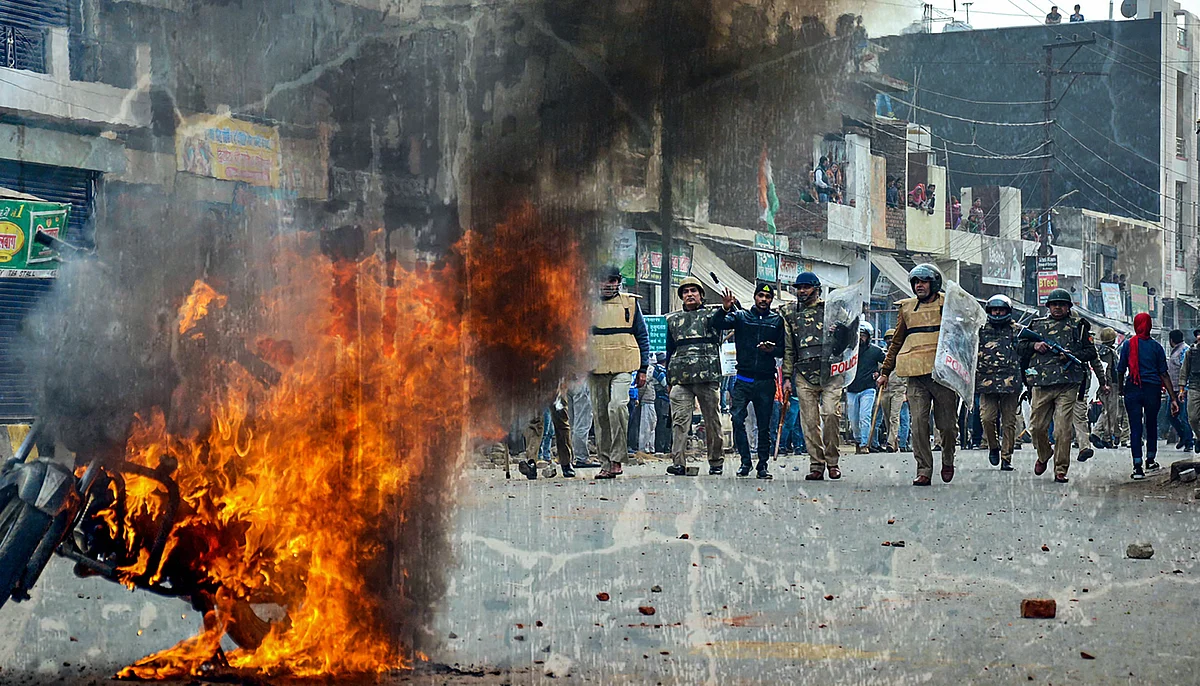 Smoke rises out of a burning vehicle during a protest against the Citizenship (Amendment) Act, in Muzaffarnagar, on 20 December.