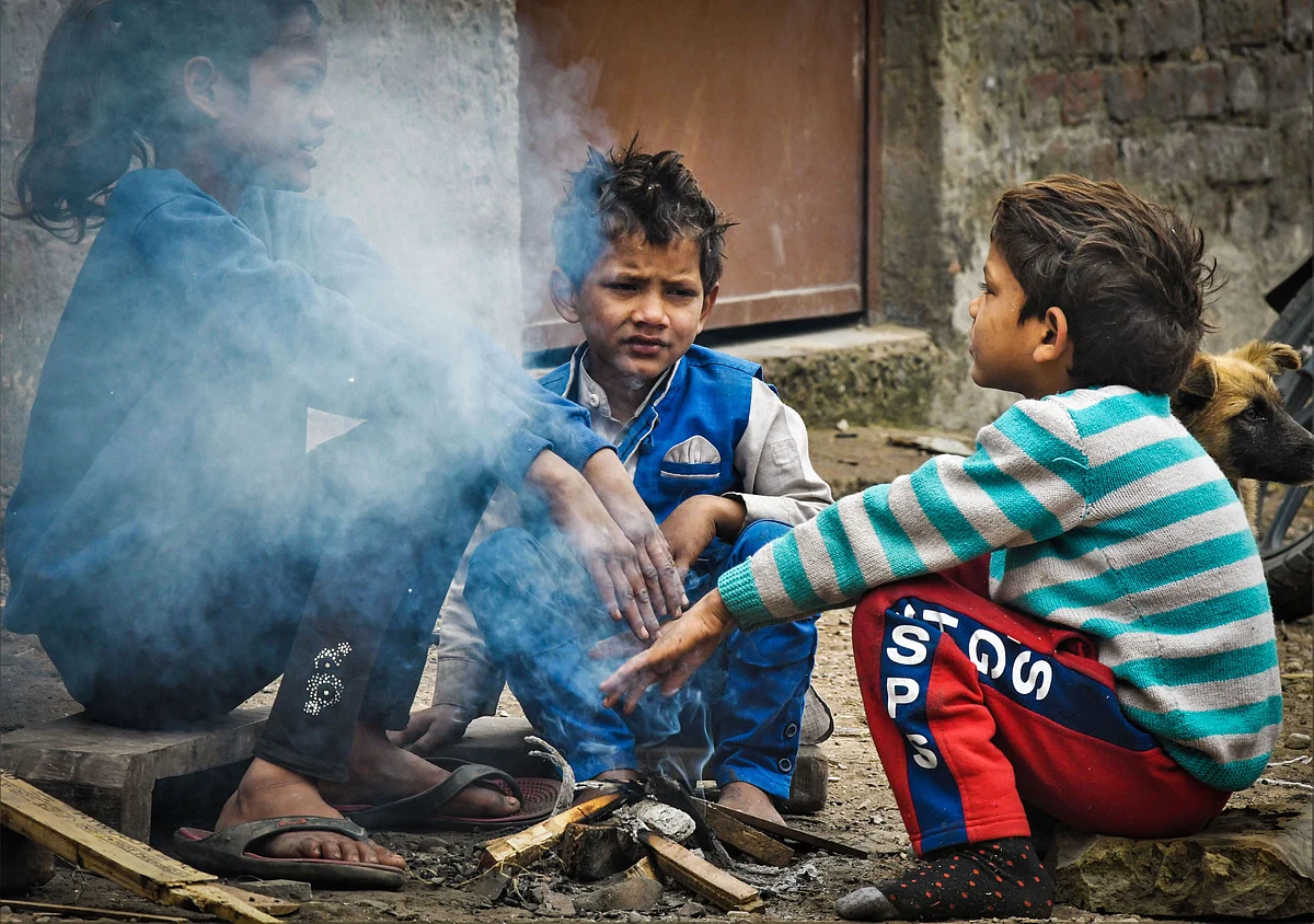 Children warm themselves near a bonfire during a cold winter day, at a village on the outskirts of Chandigarh on Friday, 27 December.