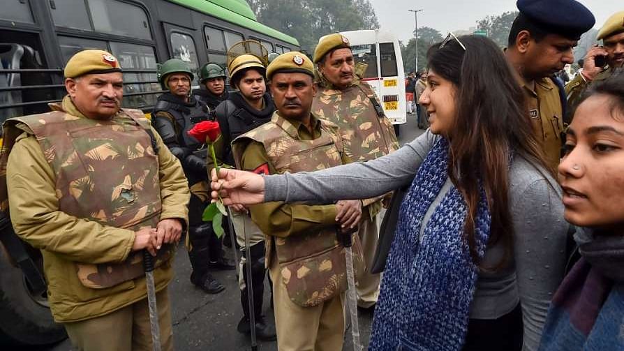 A protester offers a rose to a police personnel in Delhi.