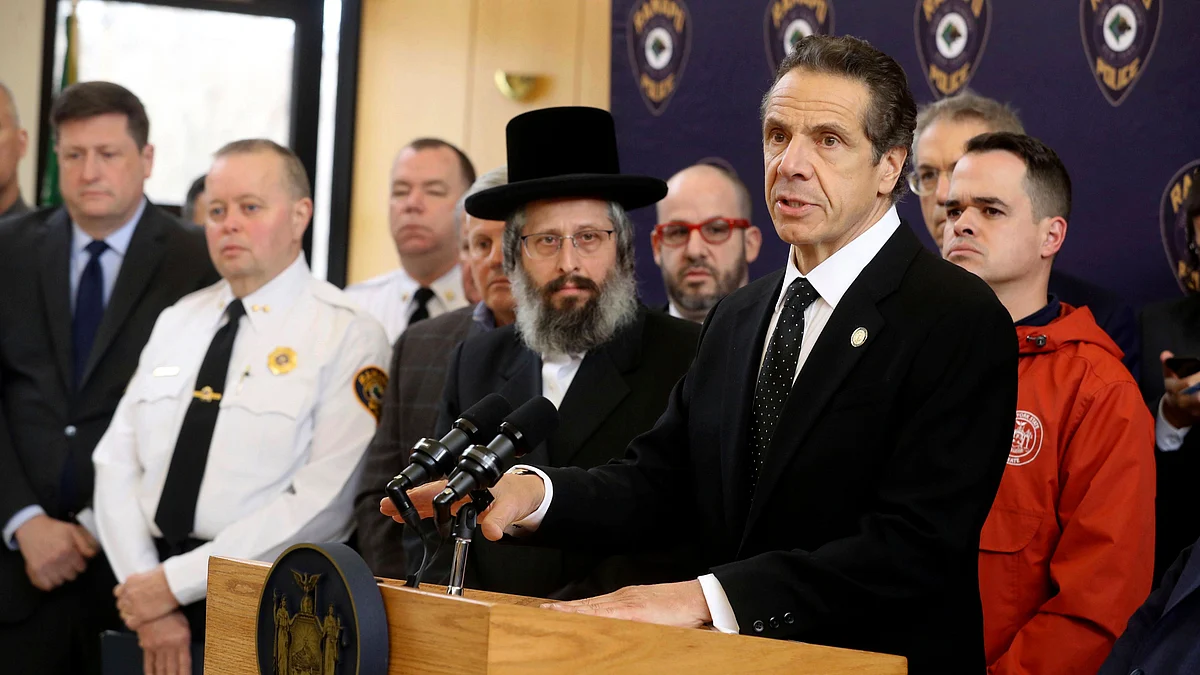 New York Gov. Andrew Cuomo, right, along with police, elected officials and community leaders, speaks Sunday, 29 December 2019, at Ramapo Town Hall in Ramapo, NY about Saturday night’s stabbings at a rabbi’s home in Monsey.