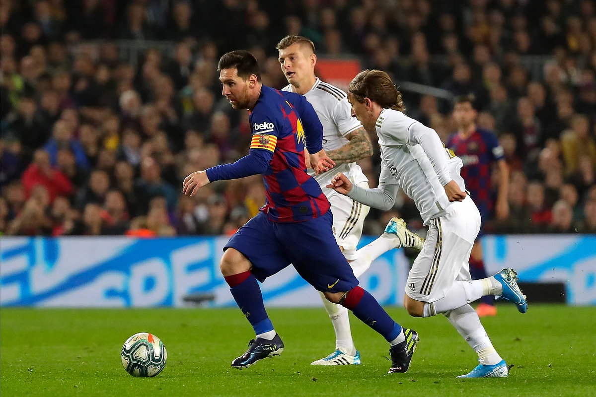 Barcelona’s Lionel Messi, left, vies for the ball with Real Madrid’s Luka Modric, right, during a Spanish La Liga soccer match between Barcelona and Real Madrid at Camp Nou.