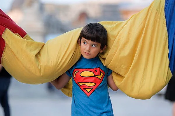 A child helps carry a a 100-metre-long Romanian flag after Romanians celebrated national anthem day in Bucharest in July 2019.