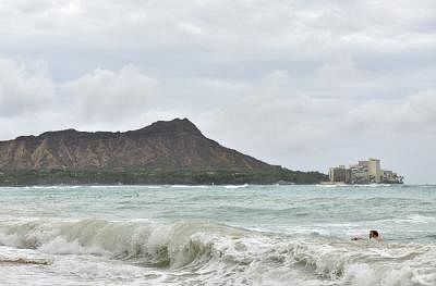 HONOLULU, Aug. 24, 2018 (Xinhua) -- A man surfs in the ocean at Waikiki beach in Honolulu of Hawaii, the United States, Aug. 23, 2018. Hurricane Lane, predicted as the biggest weather threat to Hawaii in decades, moved perilously close to the Aloha State Thursday morning, triggering heavy rain, landslide and flooding.  (Xinhua/Sun Ruibo/IANS)