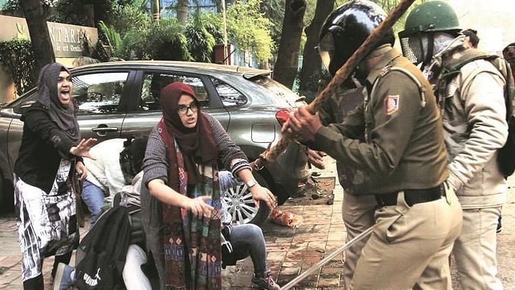 Image of Jamia students trying to protect another student from police violence. Image used for representational purposes.