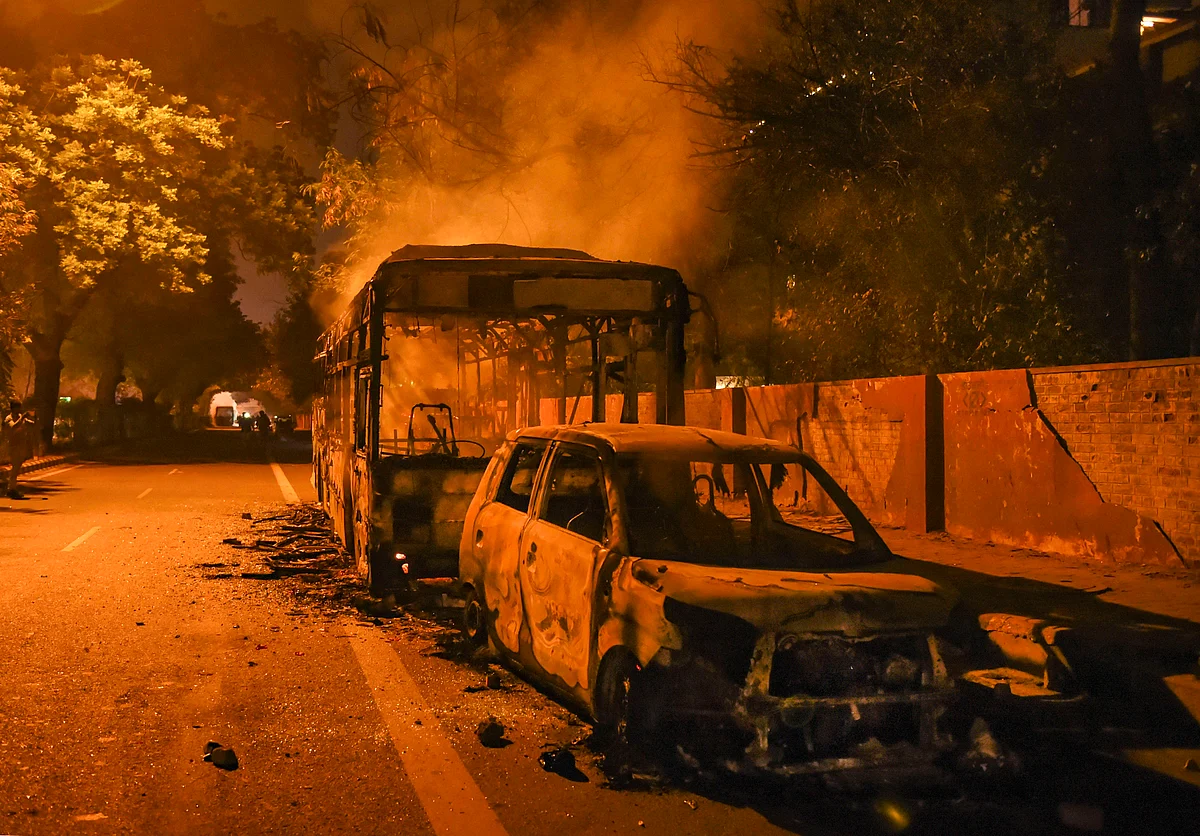 Charred remains of vehicles due to protests against Citizenship Amendment Act near Mathura Road, in New Delhi.