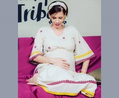 Actress Kalki Koechlin has shared her first pregnancy photograph flaunting her blossoming baby bump on social media. Kalki on Monday took to Instagram to share the image. In the photograph, the "Dev. D" actress is seen sitting on a couch in a beautiful white cotton dress.