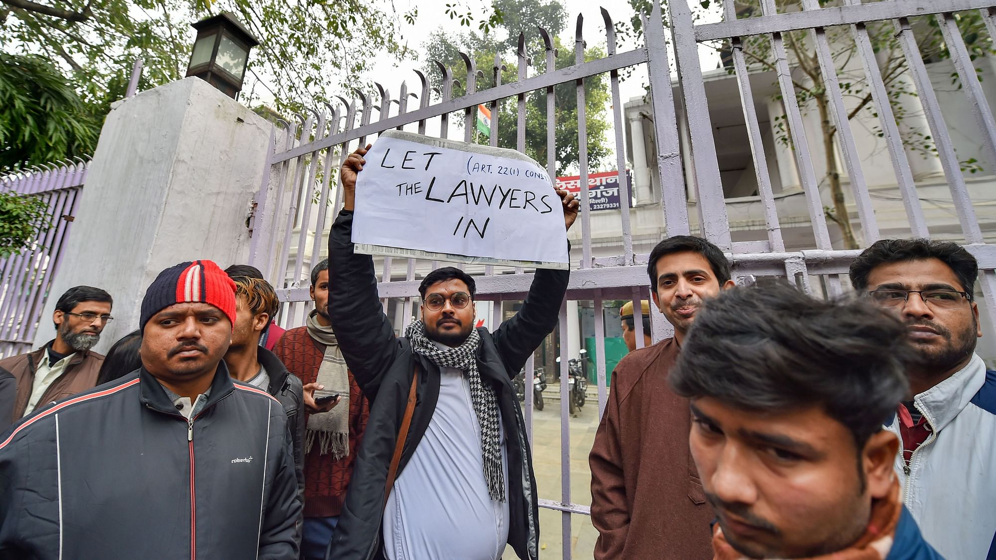 Lawyer holding a placard stands outside the Daryaganj police station on Friday.