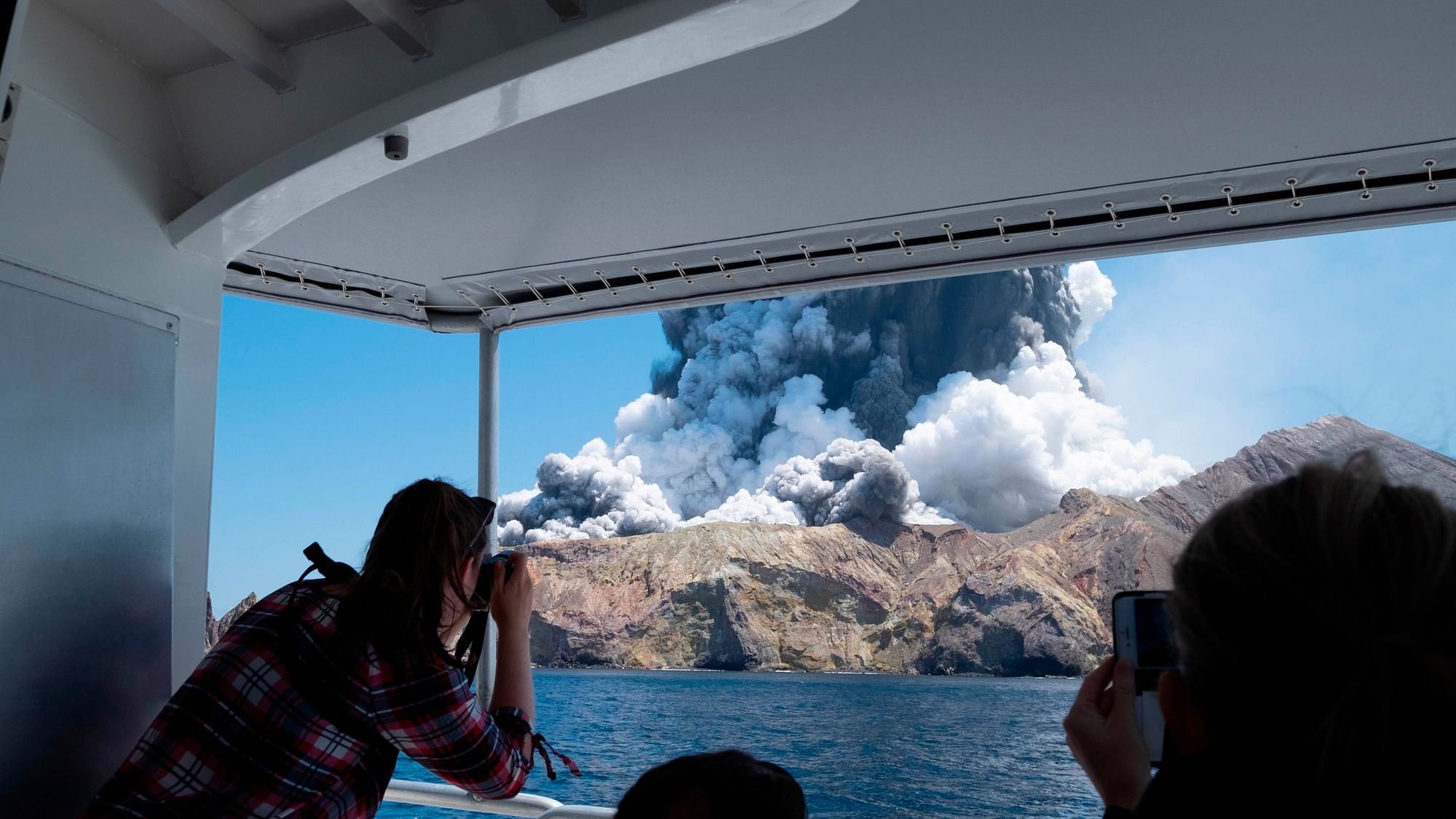  Tourists on a boat look at the eruption of the volcano on White Island, New Zealand.&nbsp;