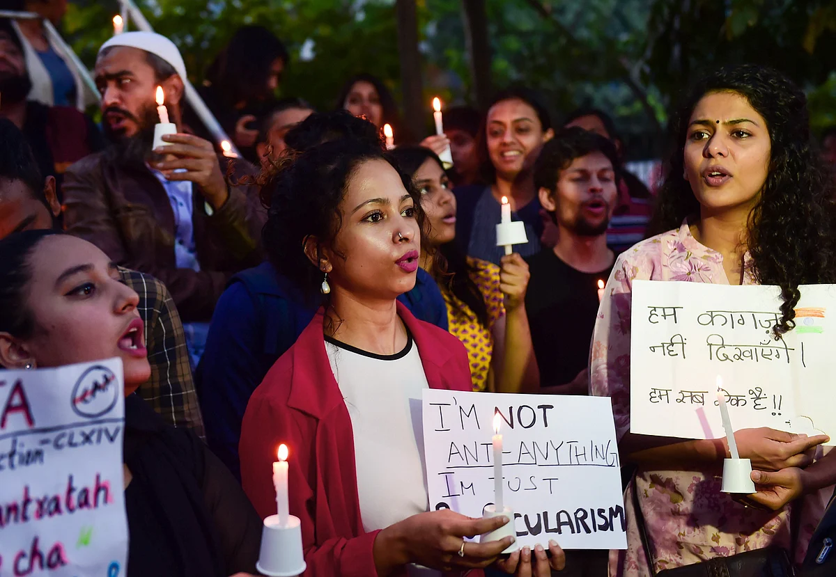 Protestors hold placards as they raise slogans during an anti-Citizenship Act candle light protest in Bengaluru on Tuesday, 24 December.