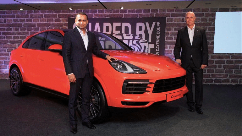 Pavan Shetty, director, Porsche India (left) with the Porsche Cayenne Coupe.&nbsp;
