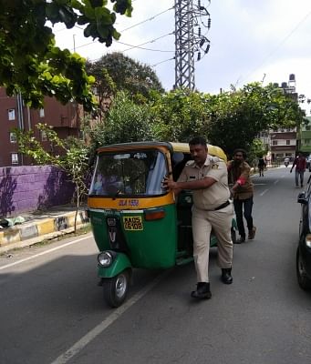 A heartwarming picture of a policeman going well beyond his scope of duty in helping out an auto rickshaw driver has gone viral on social media. The post shared by Bengaluru City Police on their Twitter, shows police personnel helping out an auto rickshaw driver to push his vehicle, which apparently stopped mid-way with captioned, "Photoa Story....Happy ending."