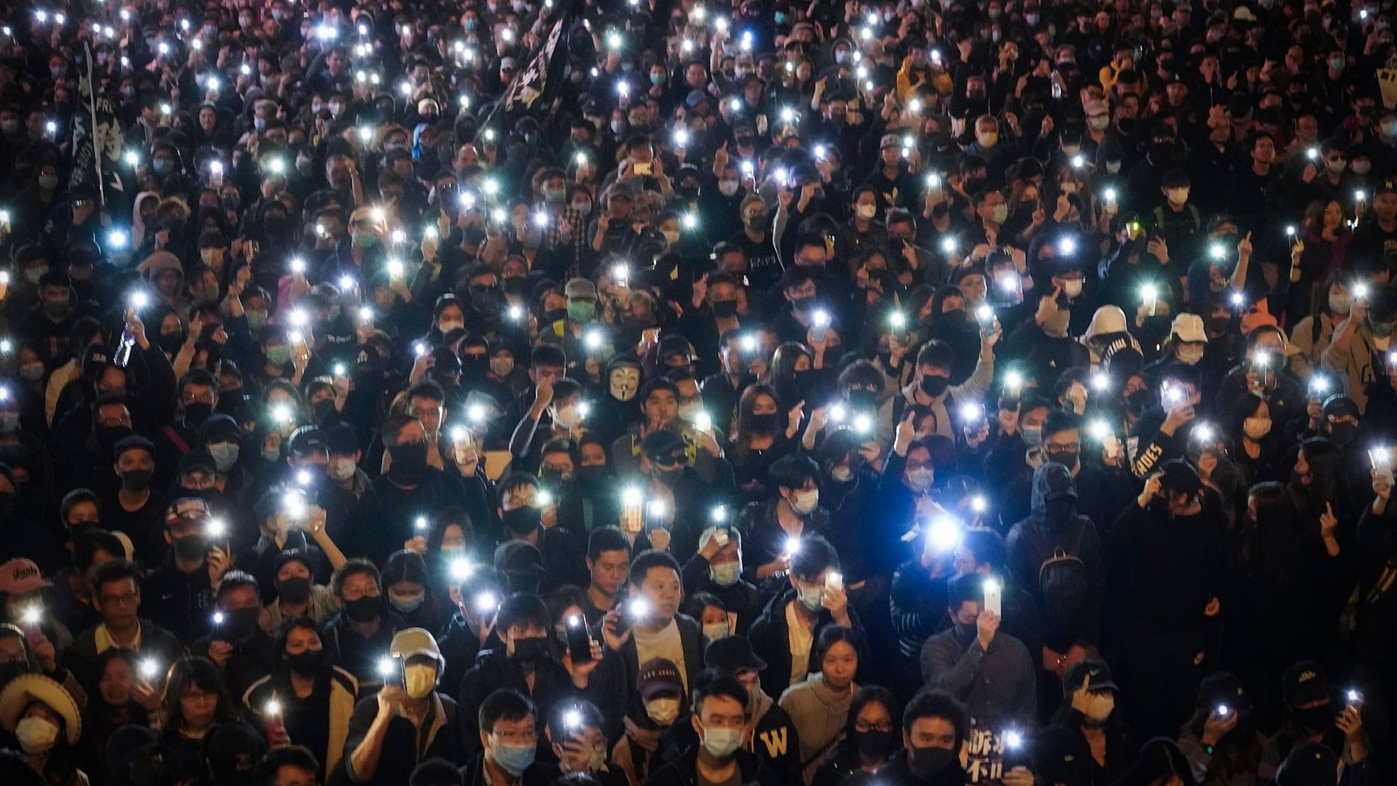 Pro-democracy protesters flash their smartphones lights as they gather on a street in Hong Kong on Sunday.