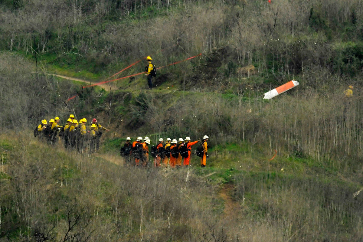 Firefighters work the scene of a helicopter crash where former NBA star Kobe Bryant died.