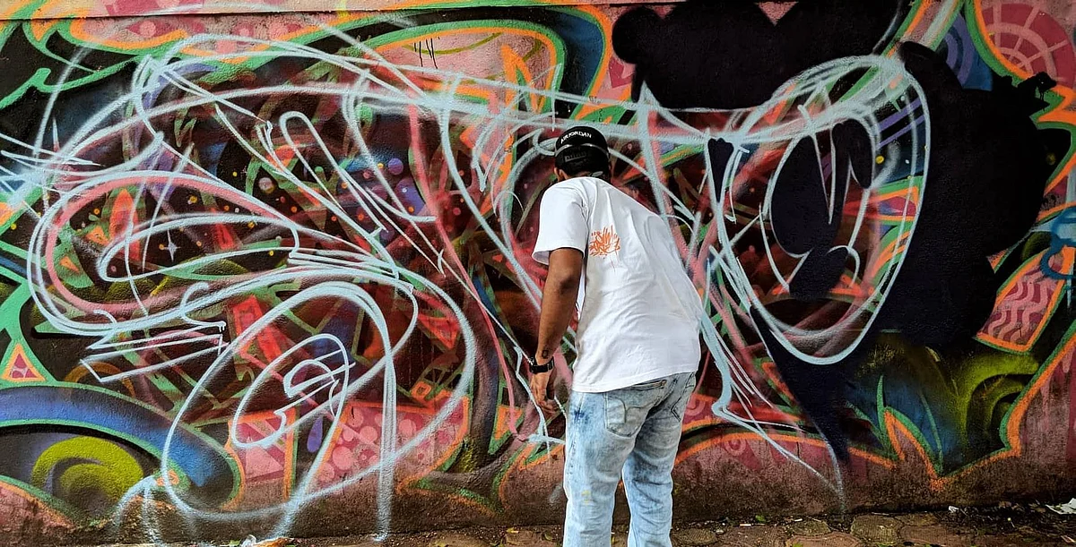 Zake, a graffiti artist, painting one of the walls near Mumbai’s bird song cafe. 