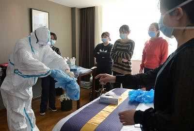 A medical worker from Beijing Anzhen Hospital demonstrates how to put on and take off protective clothing for preparations to join the fight against the novel coronavirus epidemic at a base for medical workers in Wuhan, capital of central China