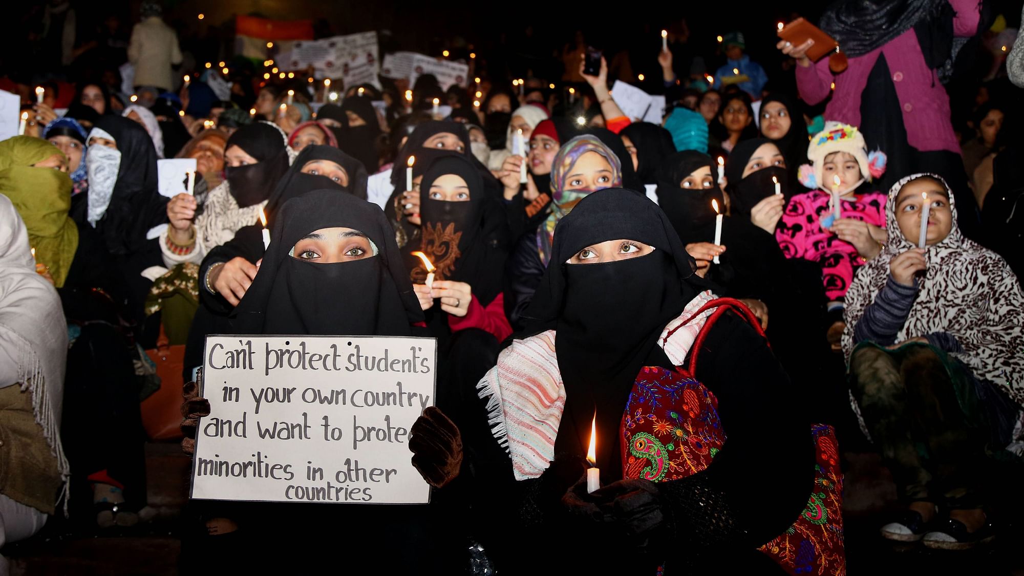 Women hold candles during a march against CAA and NRC at Jama Masjid on Wednesday, 8 January.