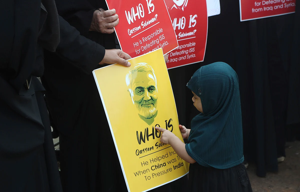An Indian girl points at a portrait of Iranian General Qassem Soleimani, who was killed in a US attack, during a protest against the US in Mumbai, on Thursday, 9 January.