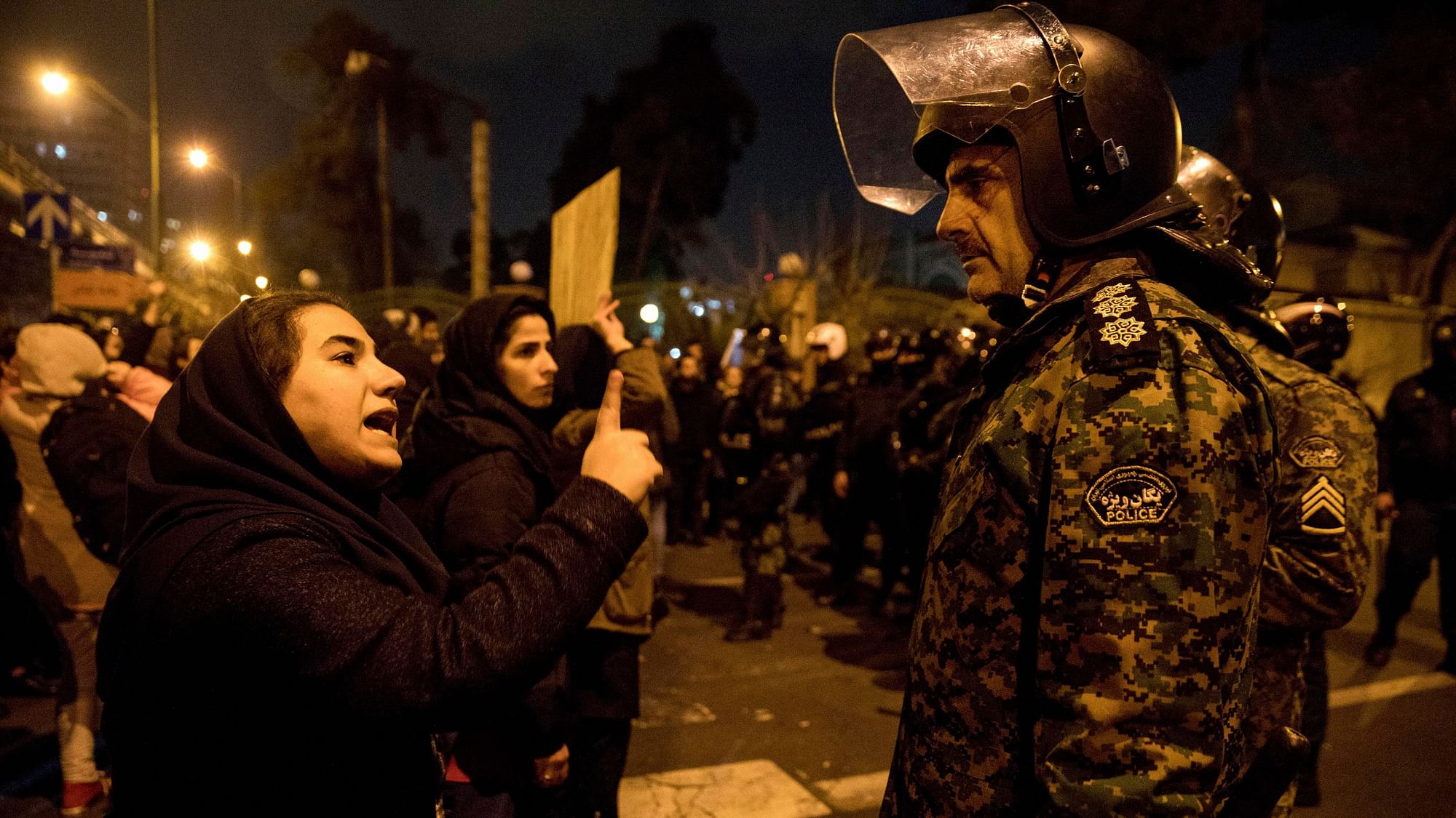 A woman attending a candlelight vigil to remember the victims of the Ukraine plane crash, talks to a policeman and asks for his sympathy.