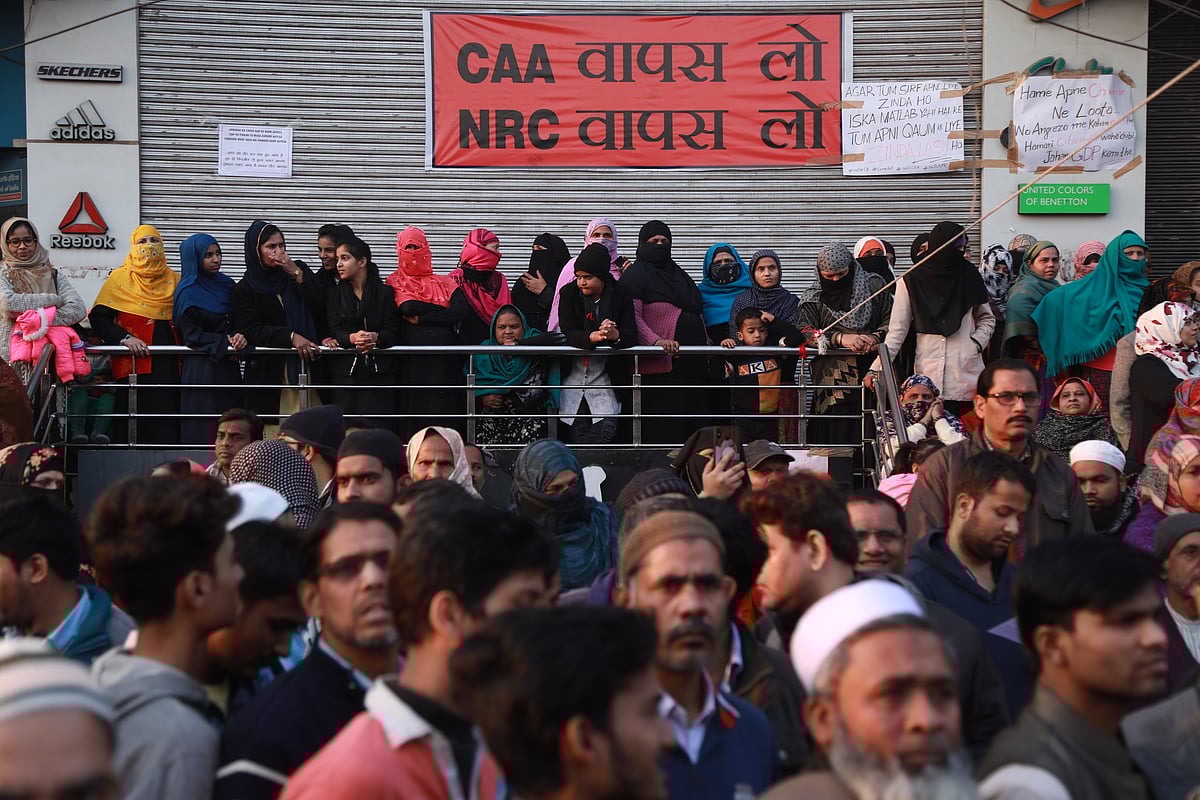 Women outside a closed store in Shaheen Bagh.&nbsp;