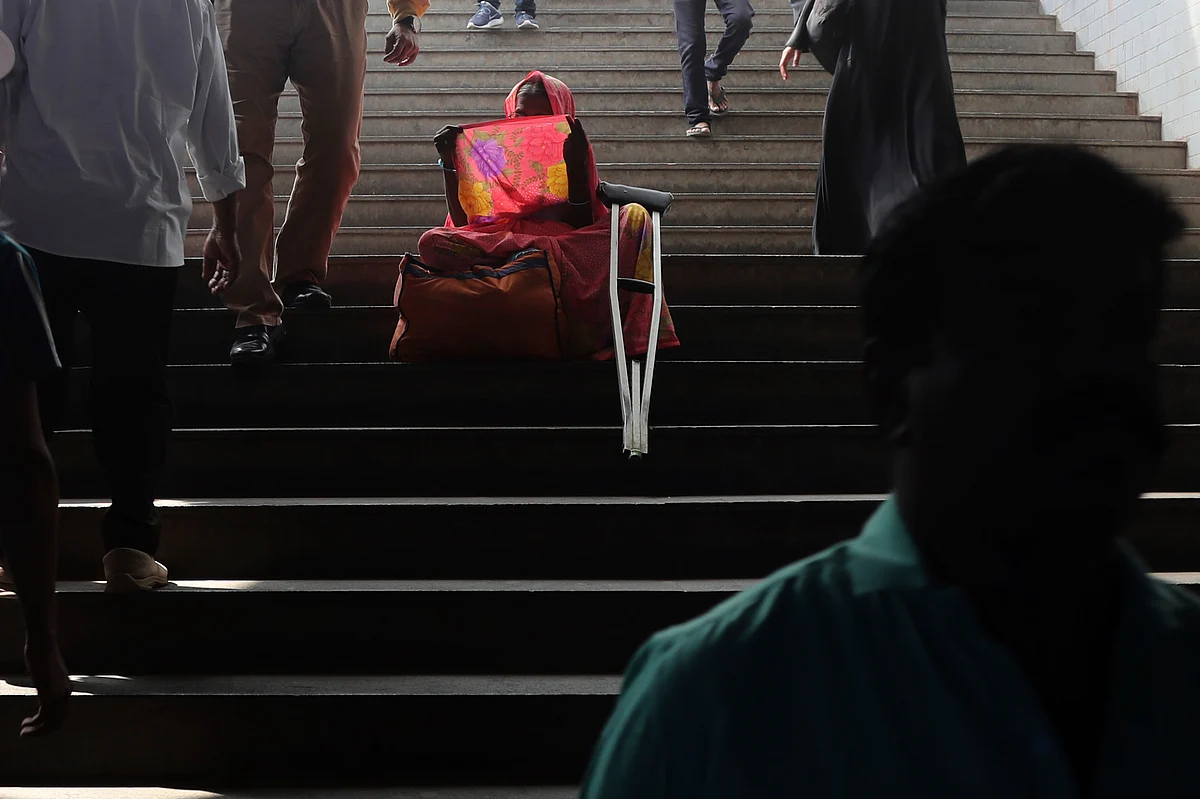 A woman seeks alms from commuters outside the Chhatrapati Shivaji Maharaj Terminus railway station in Mumbai, on Tuesday, 7 January.