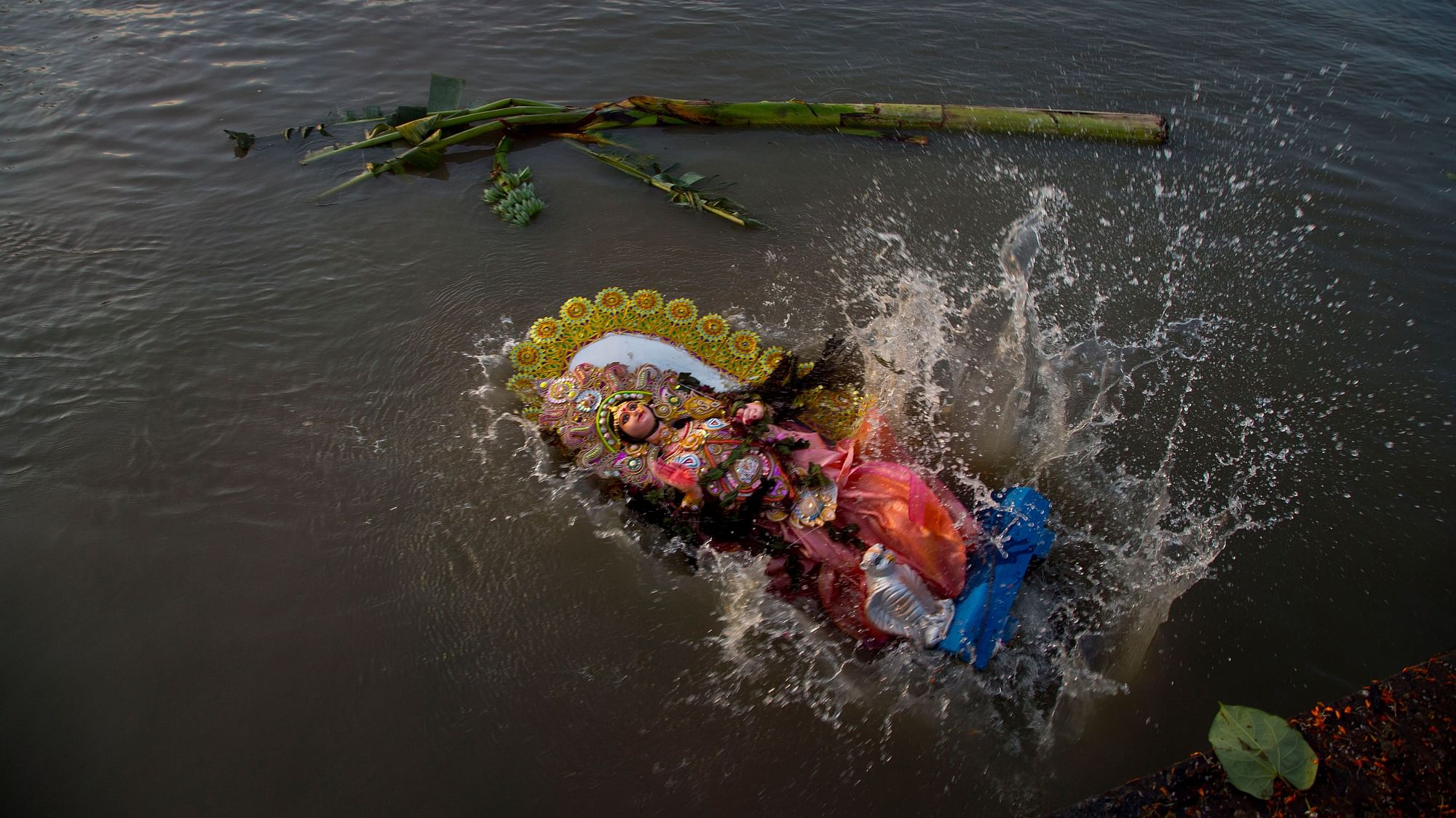 An idol of Hindu goddess Durga creates a splash in the river Brahmaputra as it is immersed marking the end of Durga Puja festivities in Guwahati, India.