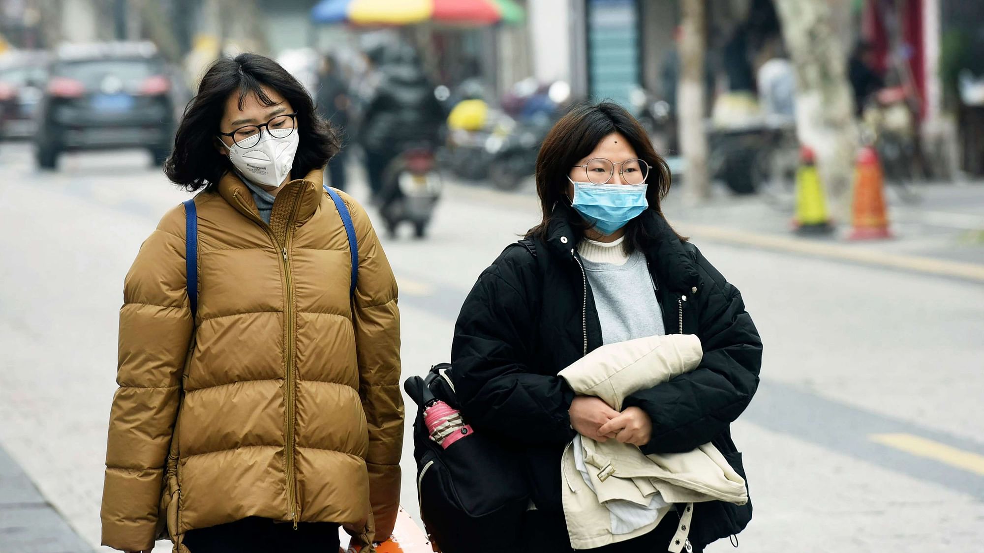Women wear face masks as they walk down a street in Hangzhou in eastern China’s Zhejiang province.&nbsp;
