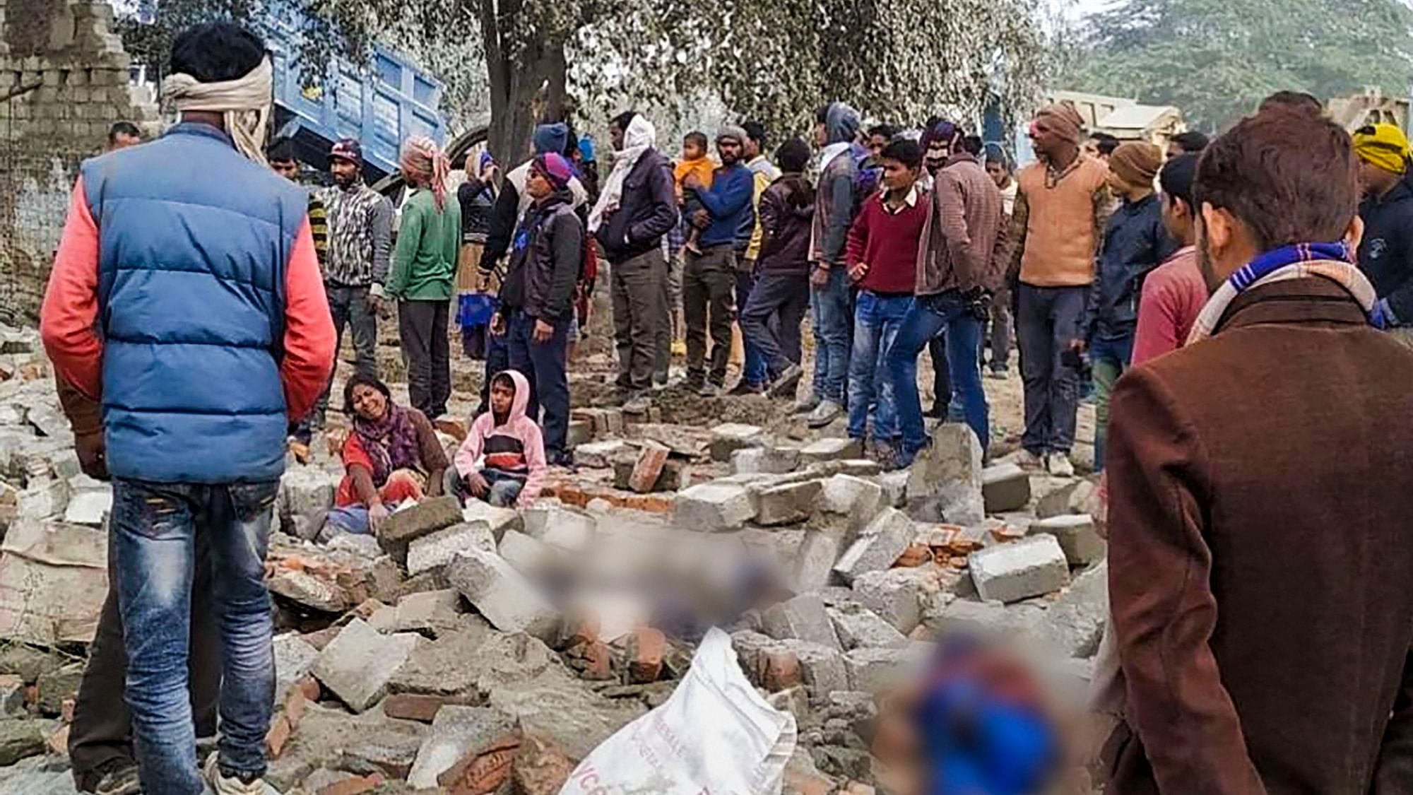 Villagers gather at the site of a wall collapse at Lakshmanpura in Jhansi.