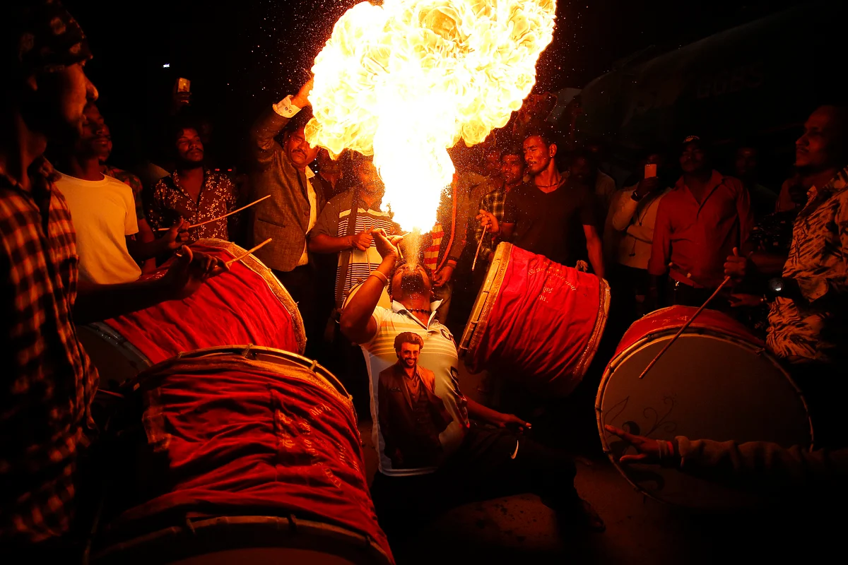 A man performs a fire act as fans of actor Rajinikanth celebrate the release of his latest film ‘Darbar’ outside a movie house in Mumbai, on Thursday, 9 January.
