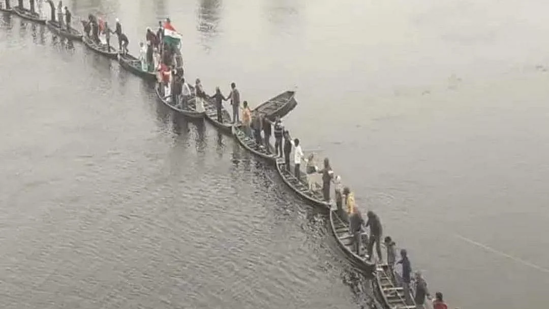 Participants in the event form a human chain standing on boats.