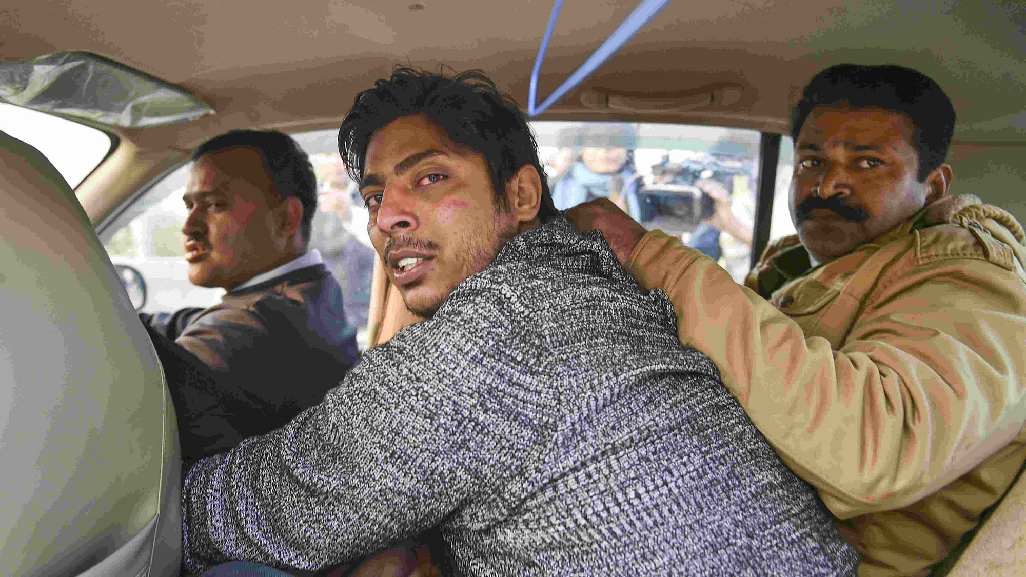 Police take away an unidentified person after he opened fire in the Shaheen Bagh area.