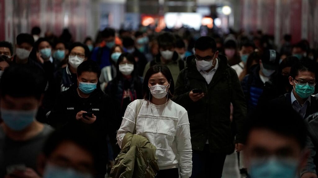 People wearing masks, walk in a subway station, in Hong Kong, Friday, Feb. 7, 2020.
