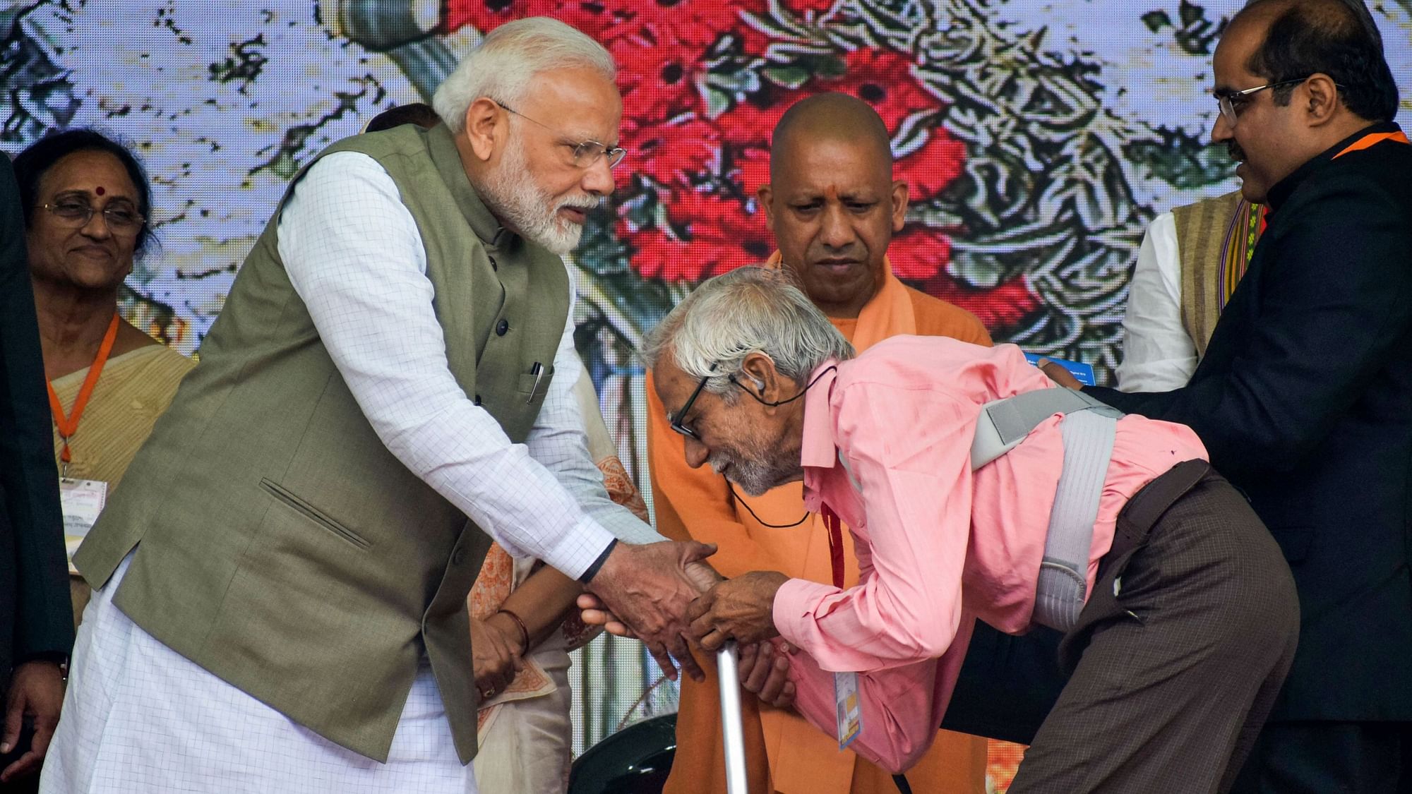 Prime Minister Narendra Modi distributes an assistive device to a differently-abled man during a programme in Prayagraj on 29 February.
