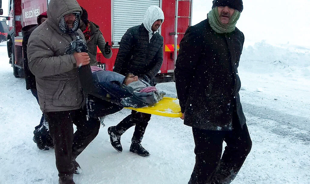 Emergency service members carry a casualty at the site of avalanche near the town of Bahcesehir, in Van province, eastern Turkey, Wednesday, 5 February.