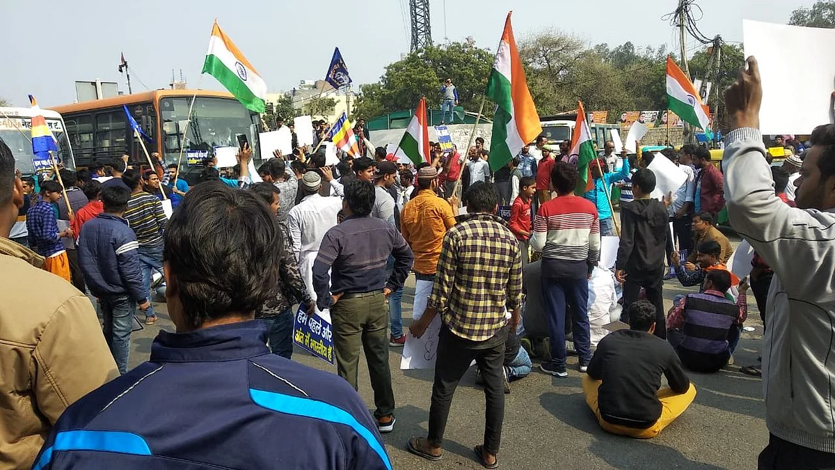 Protesters supporting the bharat bandh with Indian tri-color flags and placards at Badarpur, Mathura in New Delhi.