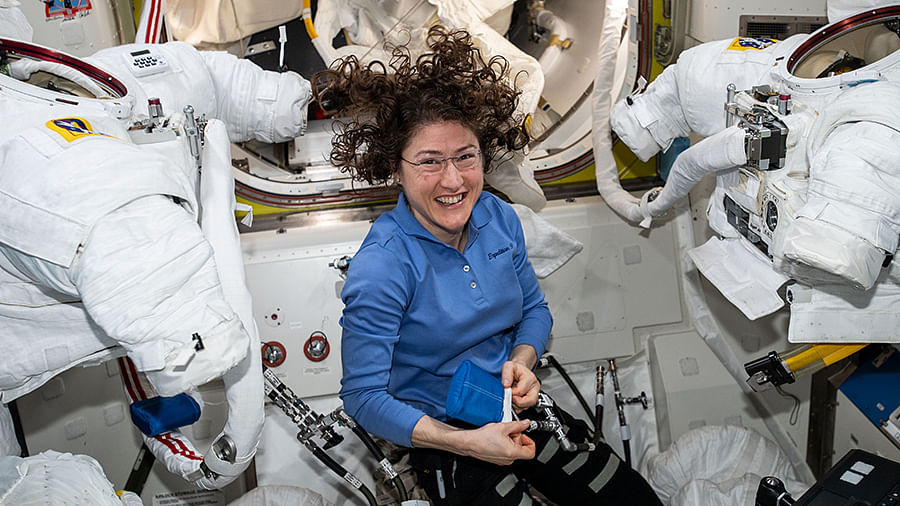 NASA astronaut Christina Koch works on US spacesuits inside the Quest joint airlock.